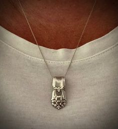 a man wearing a silver necklace with an animal's head on it