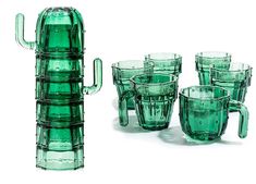 several green glass cups and a cactus vase