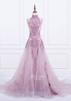 a pink dress on display in front of a white wall, with the back of it's gown covered in tulle and beading