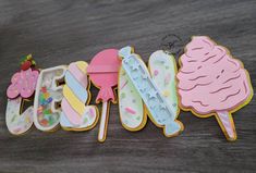 three decorated cookies sitting on top of a table next to each other with the word ice cream spelled out