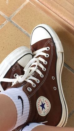 someone's feet in brown and white converse sneakers with the caption saying,