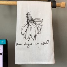 a towel hanging from a clothes line with an image of a flower and the words, your song is my soul