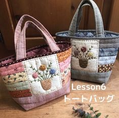 two handbags sitting on top of a wooden table next to each other with flowers in them