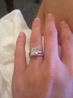 a woman's hand with a diamond ring on it