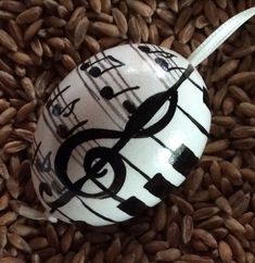 an ornament with music notes painted on it is surrounded by brown rice and sunflowers