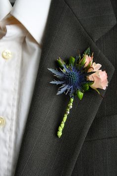 a boutonniere with flowers on the lapel of a man in a suit