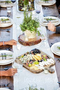 people sitting at a table with plates and wine glasses