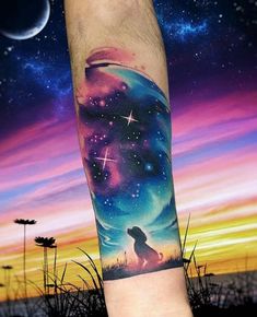 a man's arm with a colorful sky and stars tattoo on the left forearm