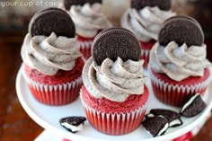 red velvet cupcakes with oreo cookies and cream frosting on a cake plate