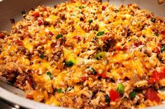 a skillet filled with rice, meat and vegetables