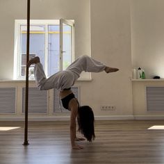 a woman is doing a handstand on the floor