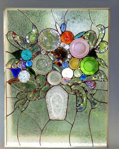 a close up of a stained glass window with many different colored items on it's surface