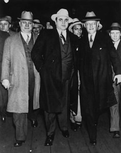 a group of men standing next to each other in front of a crowd wearing hats