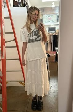 fake blonde girl trying on a white maxi skirt going until the feet, paired with a white graphic tee and black doc martens boot, taking a slefie in the mirror Nyc Winter Outfits, White Skirt Outfits, Nyc Winter, Look Grunge, White Long Skirt, Long Skirt Outfits, Rock Outfit, Maxi Skirt Outfits