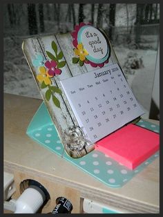 a desk with a calendar, pen and other office supplies on it's surface