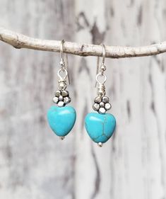 "These pretty turquoise heart drop earrings will quickly become an everyday favorite. Each turquoise howlite heart is accented with a silver flower bead. They measure 1 1/2\" in length from the top of the sterling silver earwire. See the matching BRACELET here for the perfect gift set: https://www.etsy.com/listing/220518829/genuine-turquoise-bracelet-turquoise?ref=shop_home_active_1 See more EARRINGS in my shop here: https://www.etsy.com/shop/JensBeadBox?section_id=10618715&ref=shopsection_l Turquoise Heart Beads Dangle Earrings, Turquoise Dangle Earrings With Heart Beads, Turquoise Heart Drop Earrings As Gift, Turquoise Heart Earrings, Dangle Earrings Silver, Silver Flower Earrings, Turquoise Heart, Earrings Turquoise, Heart Drop Earrings