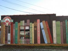 there are many books lined up on the side of this book store front wall that is made out of old books