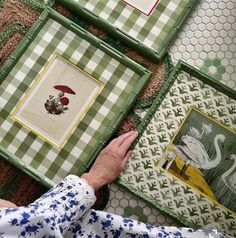 a person is looking at some pictures on the floor with their hands in front of them