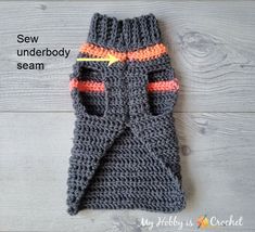 a crocheted gray mitt with an orange stripe on it