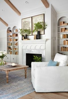 a living room filled with furniture and a fire place in front of a white fireplace