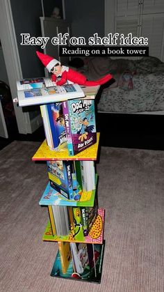 an elf is sitting on top of a stack of books with the caption easy elf shelf idea reading on a book tower