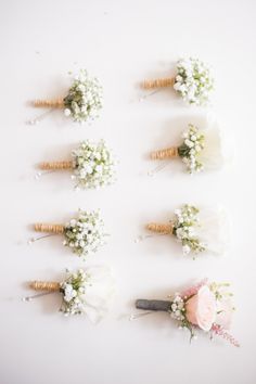 flowers arranged in the shape of letters on a white surface with corks to spell out their names