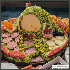 a table topped with lots of different types of food covered in leaves and cheeses