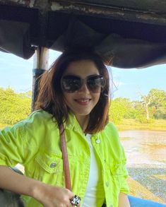 a woman in yellow jacket and sunglasses on boat