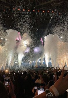 people are taking pictures with their cell phones as fireworks go off in the air