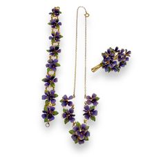 Austrian Enamelled Metal Flower Parure (Necklace, Bracelet and Brooch). This beautiful set consisting of a necklace, bracelet and brooch I believe are Austrian and date to the 1940s.  Each flower is crafted from a metal alloy that is then hand painted in a deep purple and green enamel.  The brooch is arranged to represent a bouquet of smaller flowers and is finished with a secure roll-over at the back.  The bracelet has eight flowers each linked together with two small jump rings.  It is finishe Flower Pendant Brooch For Wedding, Flower Shaped Costume Jewelry Brooch, Purple Flower-shaped Formal Jewelry, Flower Shaped Wedding Brooch, Elegant Flower Pendant Brooch Jewelry, Wedding Jewelry: Flower Pendant Brooch, Vintage Purple Flower Jewelry, Purple Jewelry With Flower Pendant And Charm, Flower-shaped Wedding Brooch