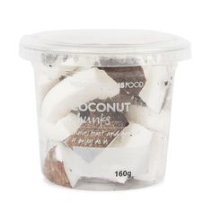 coconut chunks in a plastic container on a white background