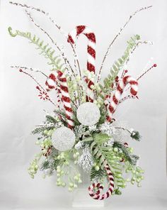 a vase filled with candy canes and greenery