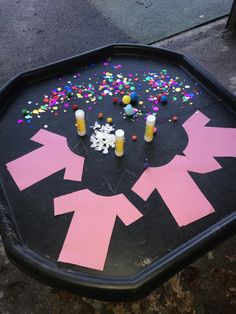 an upside down sign with candles and confetti in the shape of arrows on it