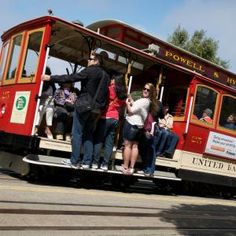 a group of people riding on the back of a trolley