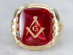 "This large vintage red glass Masonic ring has amazing, yet simply detailed shoulders, rising up from the shank and bending around the corners of the stone. The center is a classic red glass cabochon, inlaid with the gold Masonic symbol, with a nice flat profile. This ring has a substantial feel to it, and makes for a classic Masonic piece! Metal: 14K Yellow Gold Gem: Red Glass Cabochon, Gold Inlaid Masonic Symbol Gem Measures: 16mm x 14mm, Square Cushion Cut Size of Ring: 10 Marks: \"14K\" and Heirloom Red Signet Ring With Polished Finish, Classic Red Signet Ring For Formal Occasions, Classic Red Intaglio Ring, Vintage Red Hallmarked Signet Ring, Antique Red Gemstone Signet Ring, Vintage Red Signet Ring, Classic Red Gemstone Signet Ring, Classic Red Ruby Signet Ring, Classic Red Intaglio Jewelry