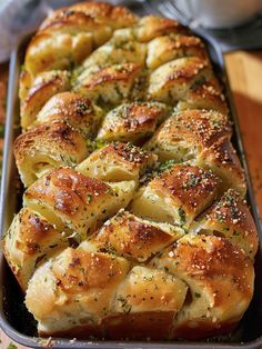 a pan filled with bread covered in cheese and herbs