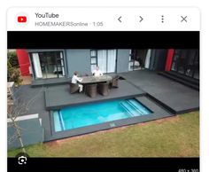 an aerial view of a house with a pool in the middle and two people sitting on it