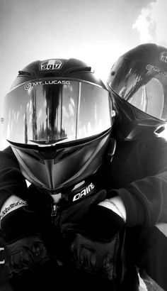 black and white photograph of two people wearing helmets