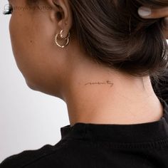 a woman with a small tattoo on her neck