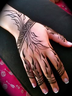 a woman's hand with henna tattoos on it