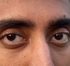 a close up of a man's face with brown eyes