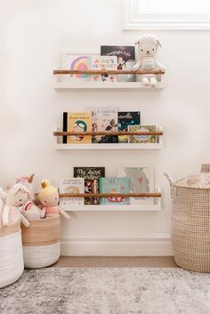 three wooden shelves with books on them in a child's room