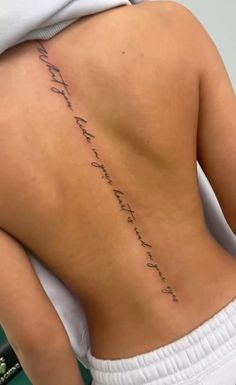 the back of a woman's lower back with writing on her left side, and an inscription written in cursive ink