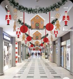 an indoor shopping mall decorated for christmas with gingerbread houses and candy canes hanging from the ceiling