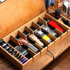 an open wooden drawer with various items in it on top of a wood floor next to bottles