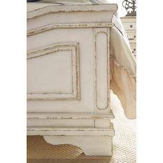 a white bed with an ornate headboard and foot board