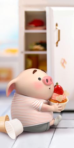 a little pig sitting on the floor eating a strawberry shortcake next to a refrigerator