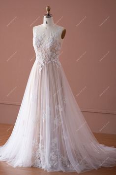 a white wedding dress on a mannequin with sheer tulle and appliques