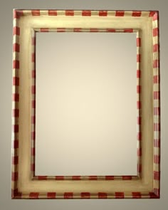 a red and white checkered framed mirror on a gray wall with an empty space in the middle