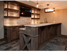 a kitchen with an island in the middle and lights on above it's cabinets